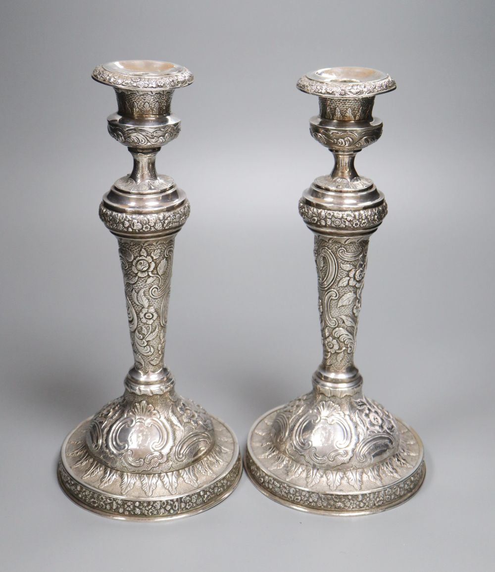 A pair of late George III silver candlesticks, with later embossed decoration, Soloman Hougham, London 1817,